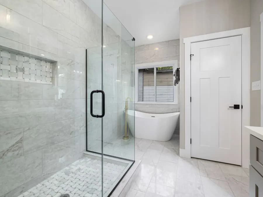 Baño moderno con ducha de vidrio y tina independiente