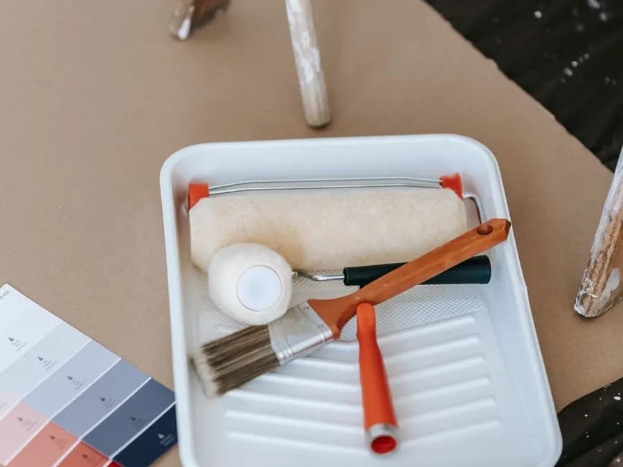 Rodillo, brocha, bandeja y muestras de color listos para pintar