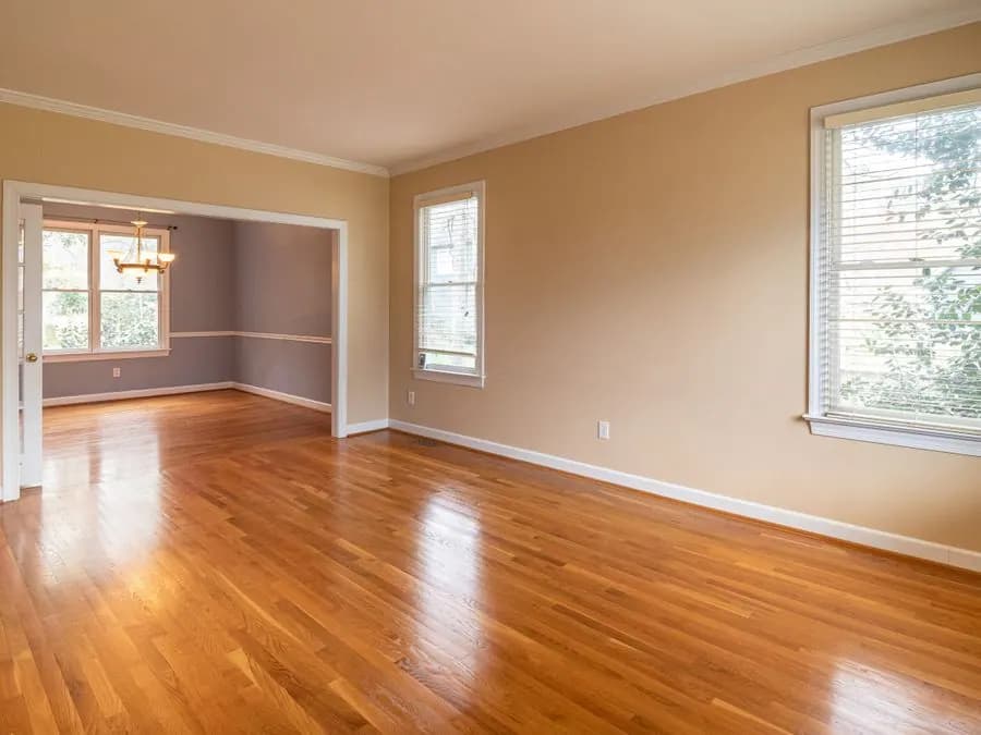 Sala con piso de madera brillante y ventanas amplias