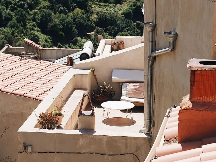 Terraza de una casa con techo de tejas y bajada de agua