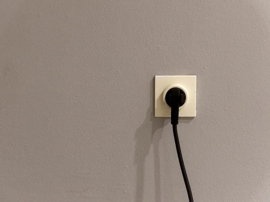 Enchufe conectado a un tomacorriente en una pared