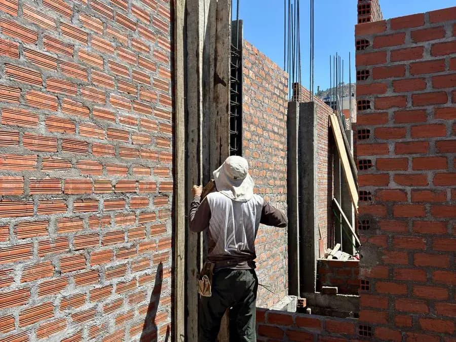 Albañil levantando un muro de ladrillo