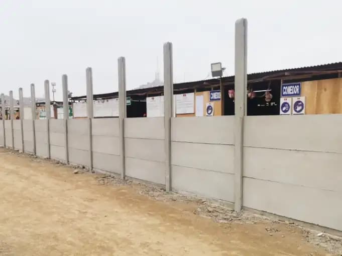 Cerco perimétrico de paneles de concreto prefabricado a lo largo de un camino, en una obra de Lima
